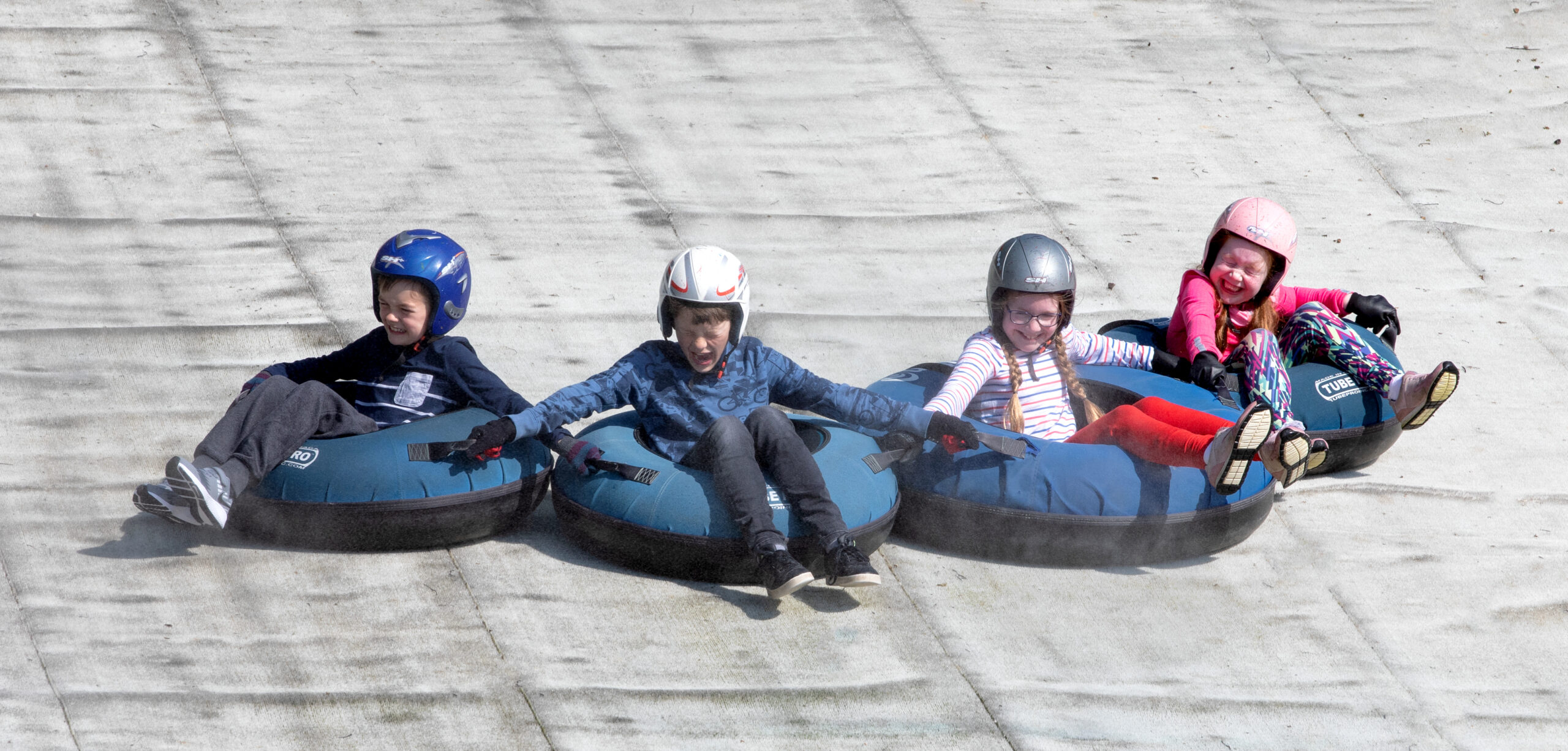 Ski_Shoot17 tubing party hold hands as they slide down the slope